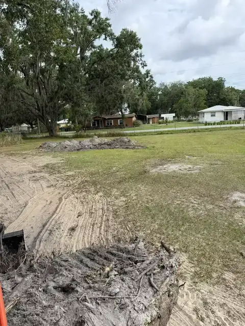Property cleanup and light grading after brush clearing in a residential yard