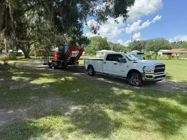 Kubota excavator and dump trailer on a residential pool dig-out support site in Polk County Florida