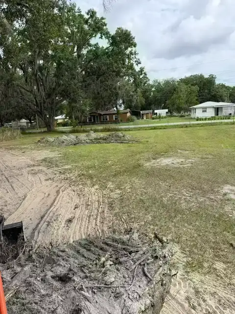 Property cleanup and light grading after brush clearing in a residential yard