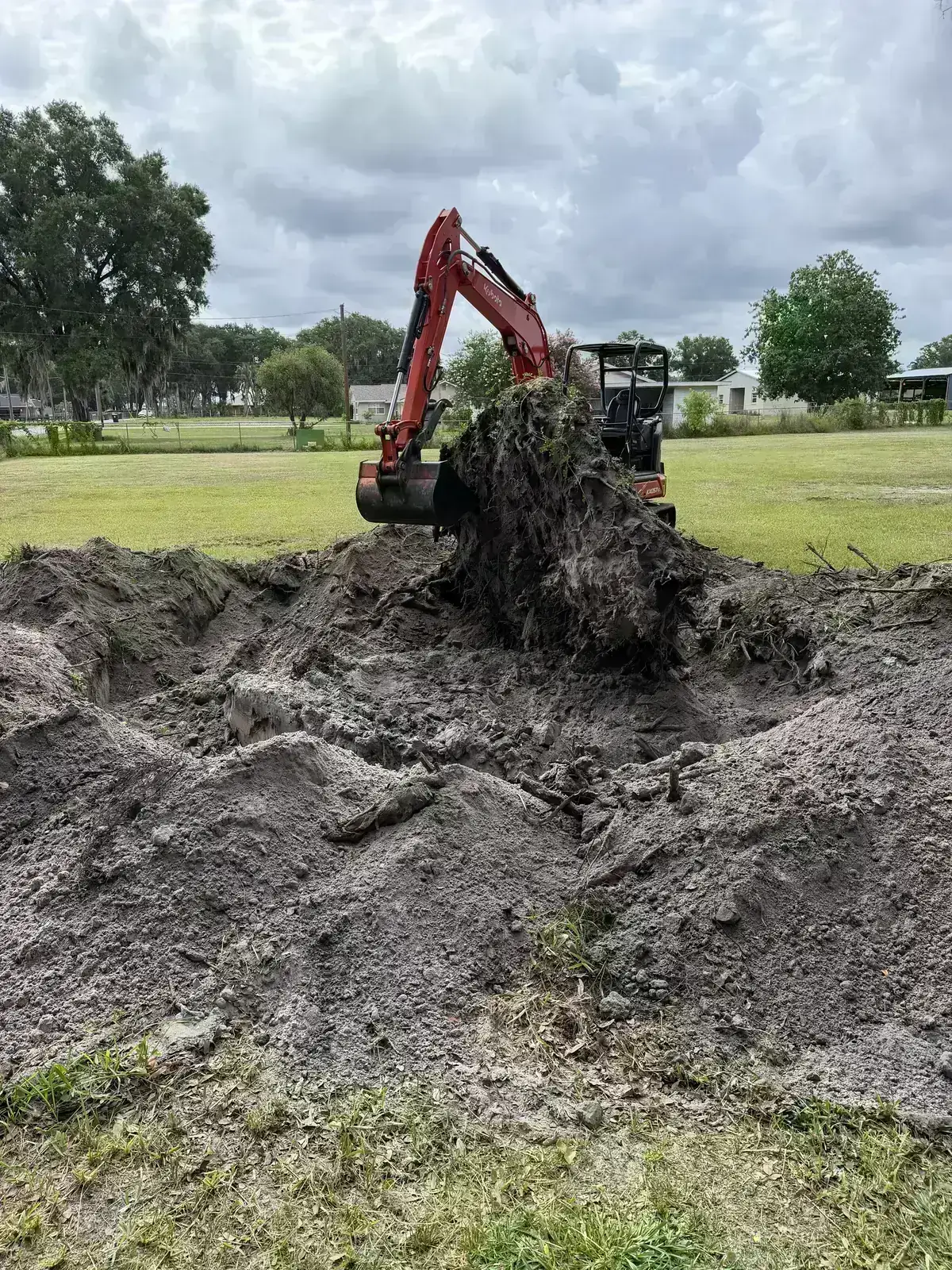 Equipment removing brush and root material during acreage cleanup